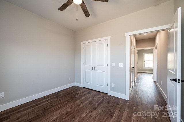 unfurnished bedroom featuring ceiling fan, dark hardwood / wood-style flooring, and a closet