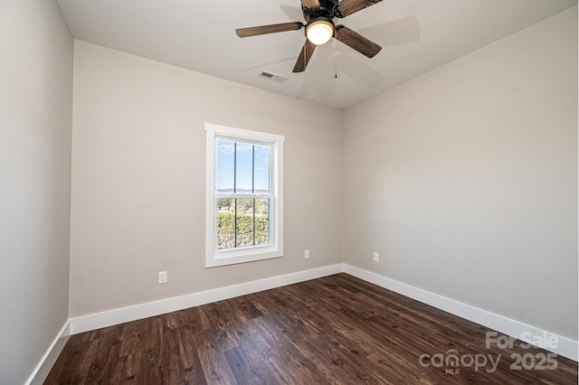 spare room with dark wood-type flooring and ceiling fan