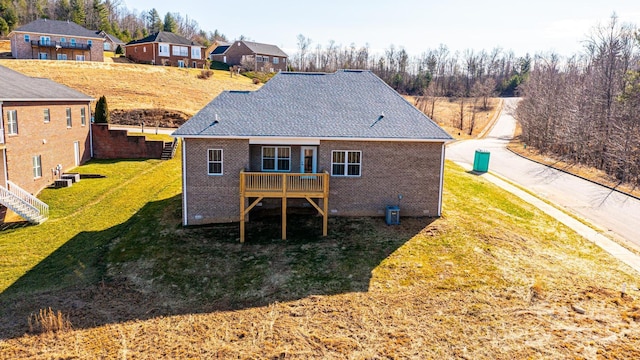 back of house featuring central AC, a deck, and a lawn