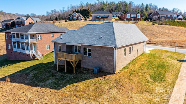 rear view of house with central AC, a yard, and a deck