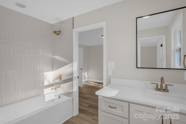 bathroom with vanity, tiled shower / bath combo, and hardwood / wood-style floors