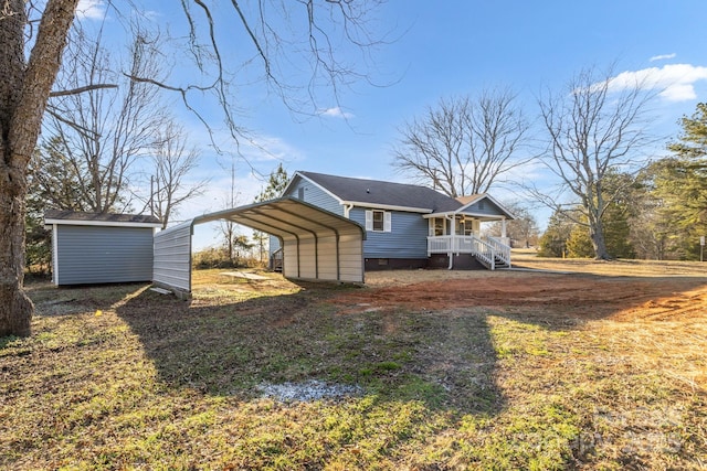 back of house with a carport, a storage unit, and covered porch