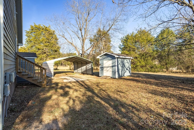 view of yard with a carport and a storage shed