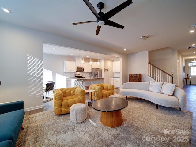 living room featuring wood-type flooring and ceiling fan