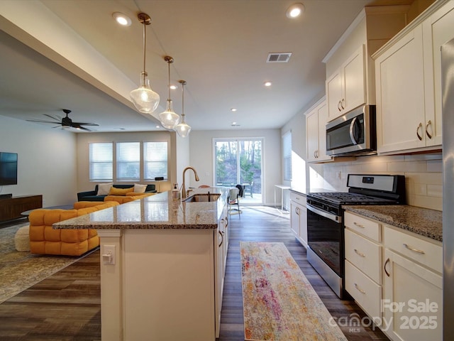 kitchen featuring pendant lighting, an island with sink, white cabinetry, sink, and stainless steel appliances