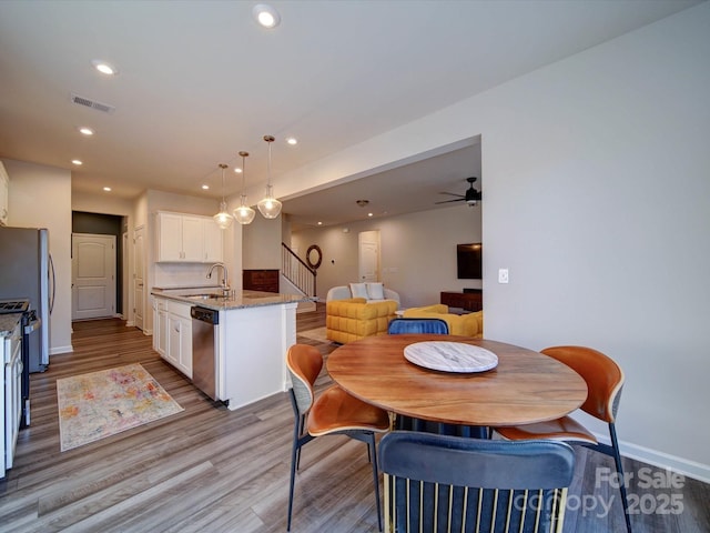 dining area featuring sink and light hardwood / wood-style floors