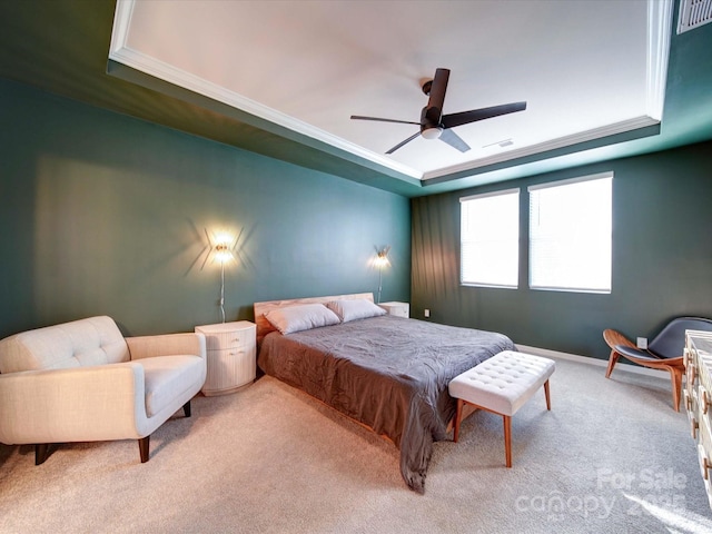 bedroom with ceiling fan, ornamental molding, a tray ceiling, and light carpet