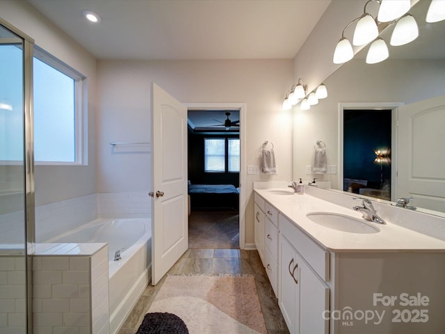 bathroom with a tub to relax in and vanity