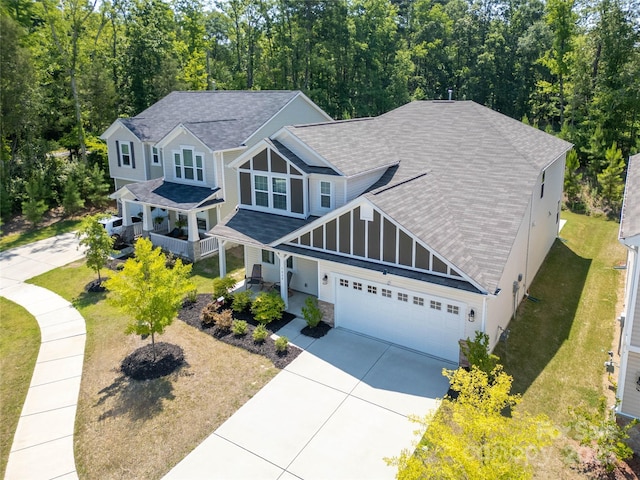 5028 Colline Ct, Charlotte, NC 28216 - view of front facade with roof with shingles, driveway, an attached garage, a front lawn, and stone siding
