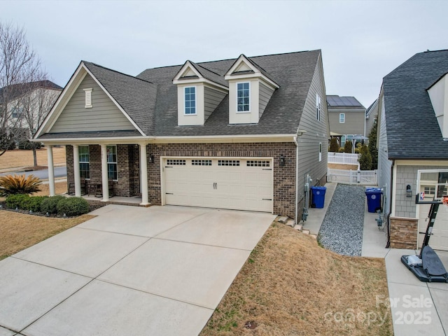 view of front of property with a porch, a garage, and a front yard