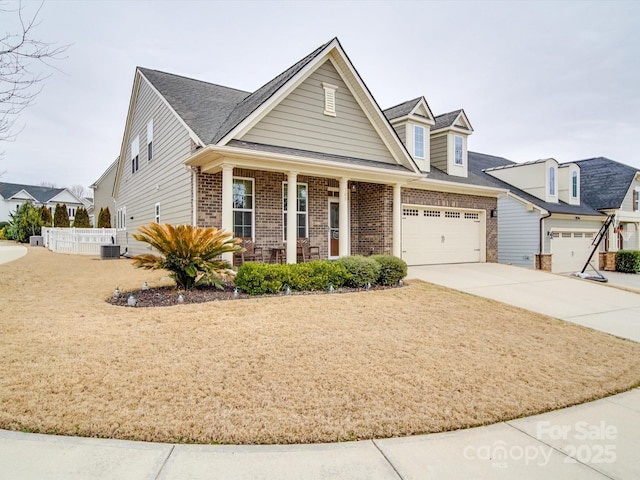 view of front of house featuring cooling unit, a porch, and a garage