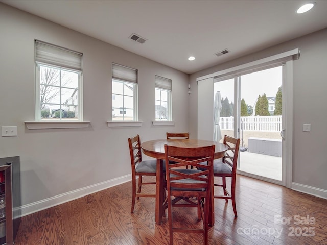 dining space featuring wood-type flooring, a wealth of natural light, and beverage cooler