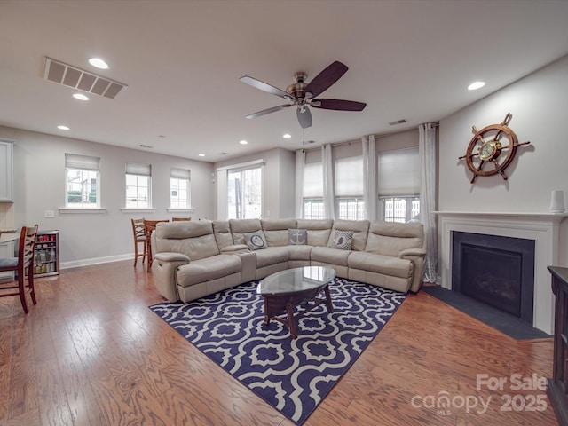 living room with hardwood / wood-style floors, a wealth of natural light, and ceiling fan