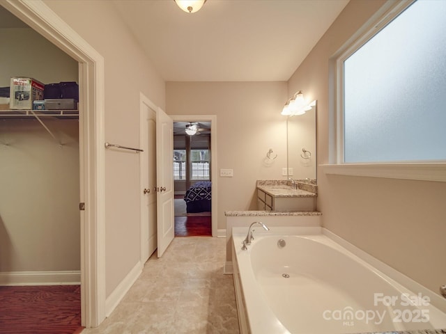 bathroom featuring vanity, tile patterned flooring, and a washtub