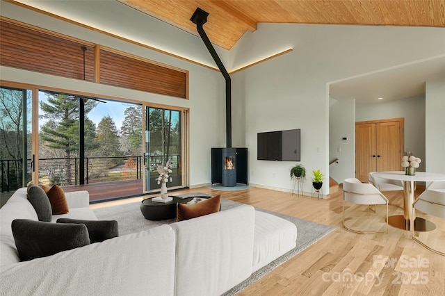 living room with wood-type flooring, high vaulted ceiling, a wood stove, and wood ceiling