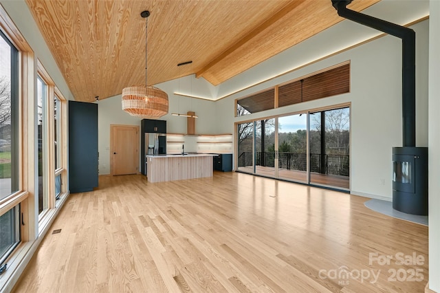 interior space featuring hanging light fixtures, wood ceiling, light wood-type flooring, and stainless steel refrigerator with ice dispenser