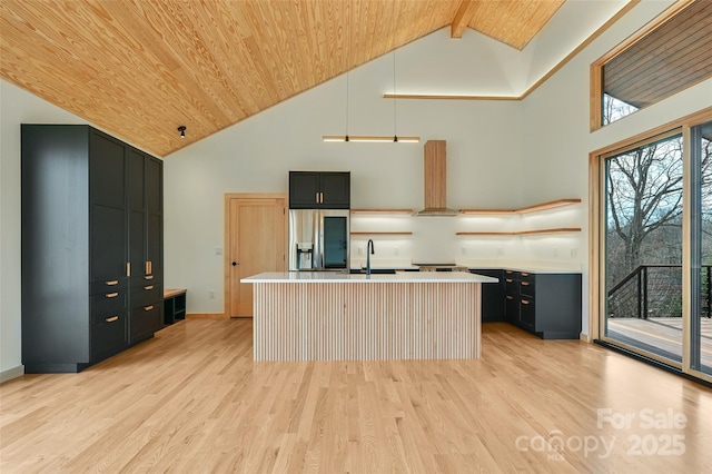 kitchen featuring wood ceiling, stainless steel fridge with ice dispenser, an island with sink, pendant lighting, and wall chimney range hood