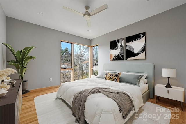 bedroom with ceiling fan and light hardwood / wood-style flooring