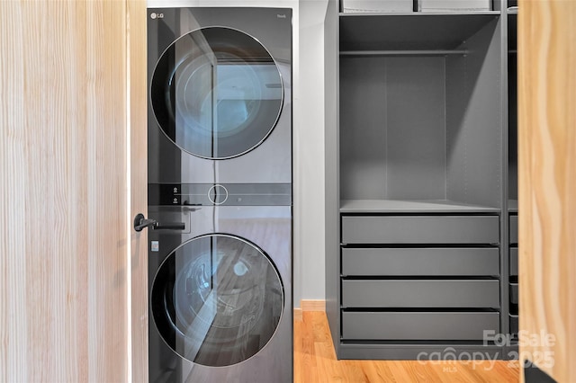 washroom featuring stacked washer and dryer and hardwood / wood-style floors