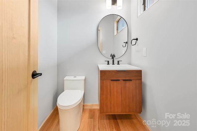 bathroom with hardwood / wood-style flooring, vanity, and toilet