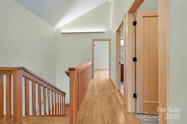 hallway featuring vaulted ceiling and light hardwood / wood-style floors