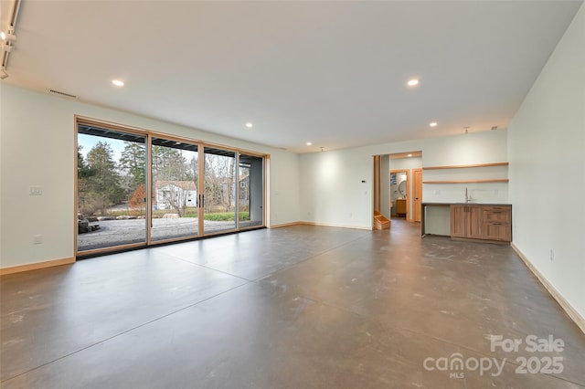 unfurnished living room featuring sink