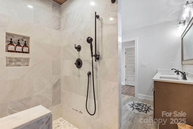 bathroom with vanity, wood-type flooring, and a tile shower