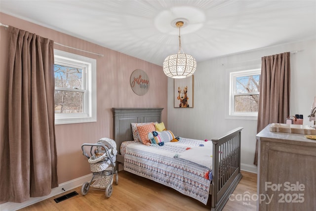 bedroom with multiple windows and light wood-type flooring