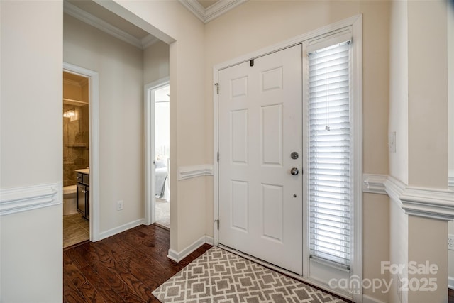 foyer entrance with ornamental molding and dark hardwood / wood-style flooring