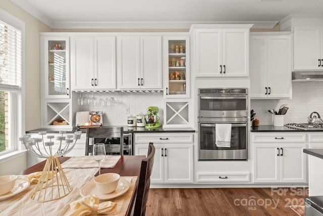 kitchen with crown molding, white cabinets, and appliances with stainless steel finishes