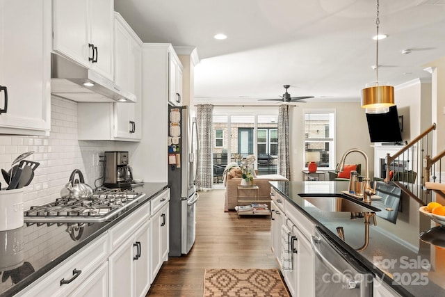 kitchen with sink, white cabinetry, hanging light fixtures, stainless steel appliances, and dark hardwood / wood-style flooring