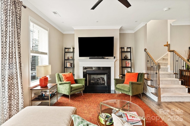 living room with ornamental molding, hardwood / wood-style floors, and ceiling fan