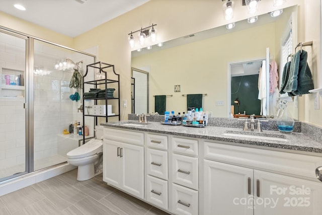 bathroom with a shower with door, vanity, and toilet