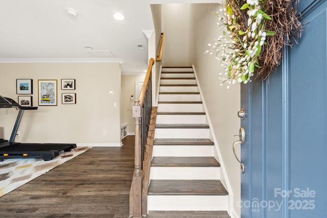 stairs featuring crown molding and hardwood / wood-style flooring