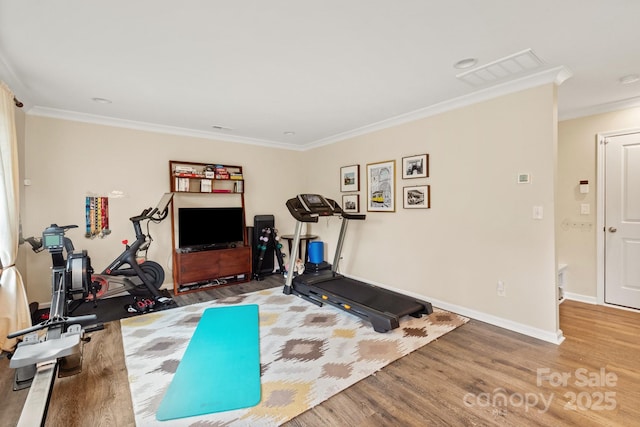 exercise area with wood-type flooring and ornamental molding