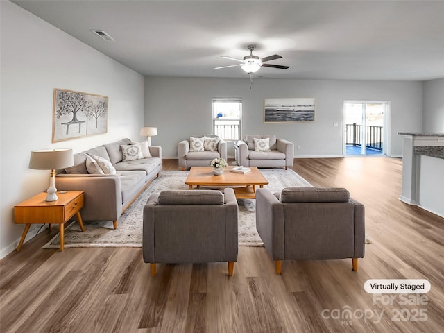 living room with hardwood / wood-style flooring, plenty of natural light, and ceiling fan