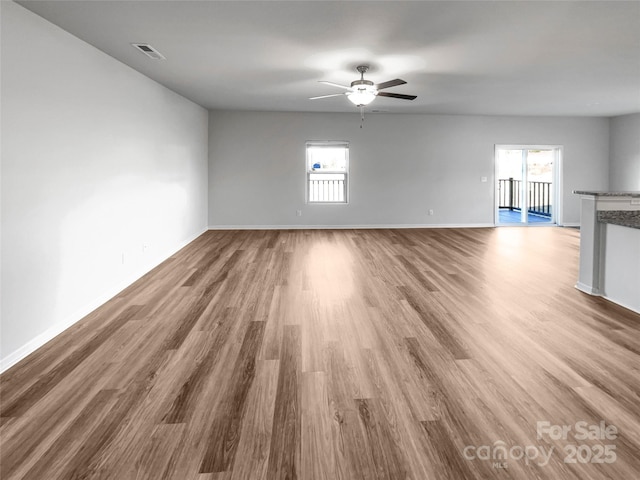 unfurnished living room with hardwood / wood-style flooring and ceiling fan