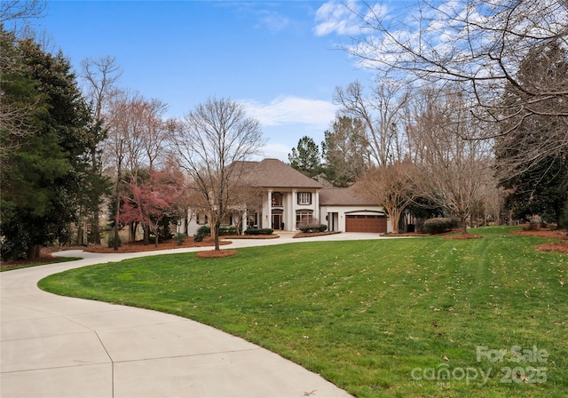 view of front facade featuring concrete driveway, a front yard, and stucco siding