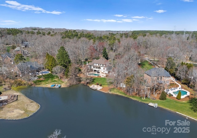 aerial view with a water view and a wooded view