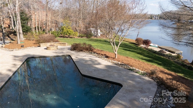 view of storm shelter featuring a patio, a lawn, and a water view