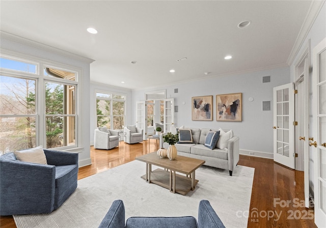 living room with wood finished floors, baseboards, recessed lighting, ornamental molding, and french doors