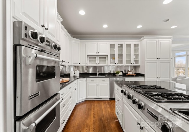 kitchen with a sink, appliances with stainless steel finishes, and white cabinetry