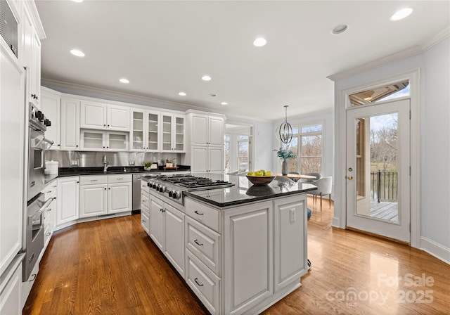 kitchen with dark countertops, appliances with stainless steel finishes, a center island, and white cabinetry