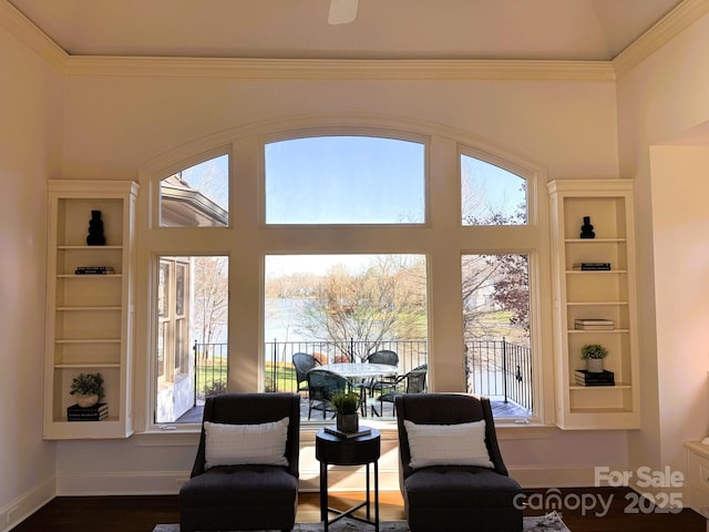 sitting room featuring dark wood finished floors, a towering ceiling, baseboards, and ornamental molding