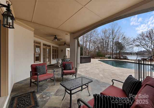 view of patio featuring an outdoor pool, a water view, a ceiling fan, and a hot tub