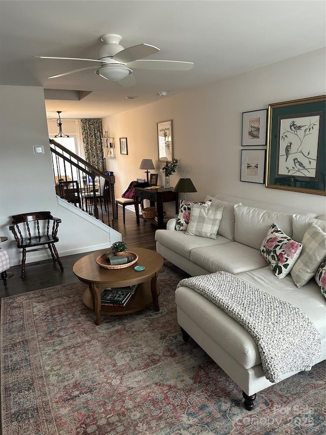 living room with dark wood-type flooring and ceiling fan