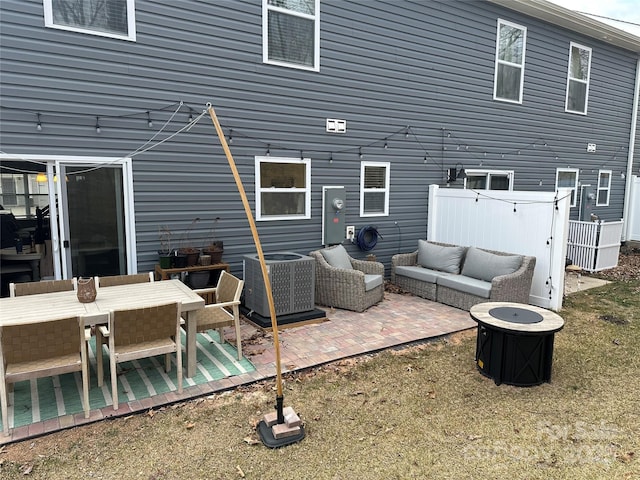 back of house featuring central AC, outdoor lounge area, a patio area, and a lawn