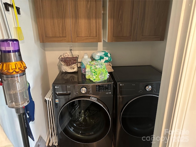 laundry room with washing machine and dryer and cabinets