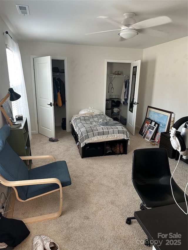 carpeted bedroom with a spacious closet, ceiling fan, and a closet