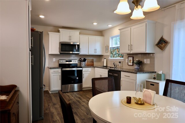 14 Malcolm Ct, Candler, NC 28715 - kitchen with white cabinets, backsplash, appliances with stainless steel finishes, and dark wood-style flooring